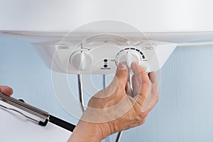 Person adjusting temperature of electric boiler