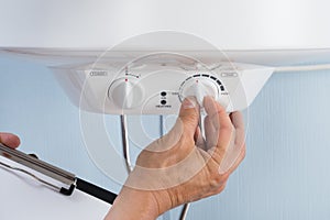 Person adjusting temperature of electric boiler photo