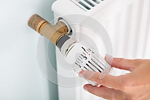 Person Adjusting Thermostat Radiator Valve