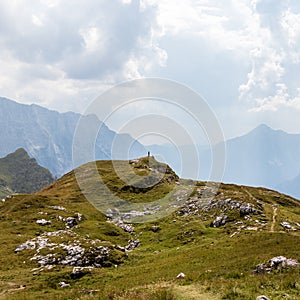 Person alone around Alps between huge Mountain Chains inside beautiful Nature. Summer Day Panorama in Julian Alps, Triglav