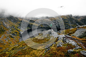 Person on alpine lake, Munken Mountain trail, Lofoten Islands, Norway