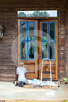 Person applies stain while refinishing wooden front door