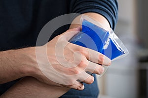 Person Applying Ice Gel Pack On An Injured Elbow