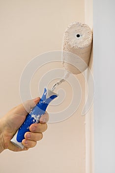 Person applying paint on wall