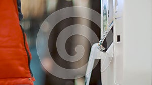 Person attach smartphone to a self-service terminal. Guy makes a purchase online using a NFC payment. Man makes online