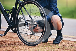 Person, bike and wheel repair outdoor for training, triathlon sports and transportation problem. Closeup of athlete