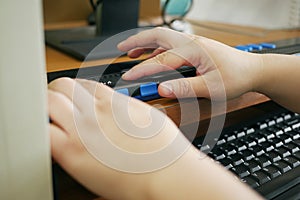 Person with blindness disability`s hands using computer with braille display or braille terminal a technology assistive device