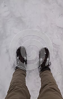 Person with brown pants and leather boots on the snow