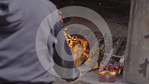 A person burns joss papers or offerings papers in a buddhist temple