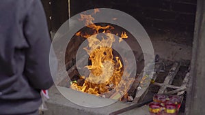 A person burns joss papers or offerings papers in a buddhist temple