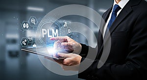 A person in a business suit using a tablet with a blue holographic display. The