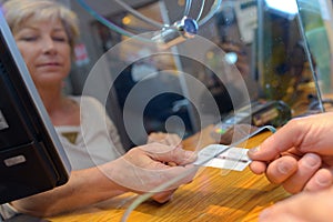 Person buying movie tickets from female seller at cinema