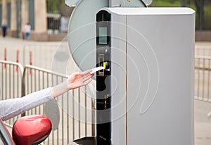Person inserting into or removing ticket from parking machine.