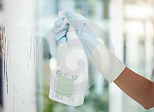 Person, cleaner and window with spray bottle for disinfection, housekeeping or cleaning service at home. Closeup of maid