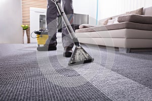 Person Cleaning Carpet With Vacuum Cleaner