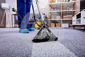 Person Cleaning Carpet With Vacuum Cleaner