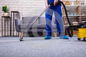 Person Cleaning Carpet With Vacuum Cleaner