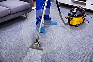 Person Cleaning Carpet With Vacuum Cleaner