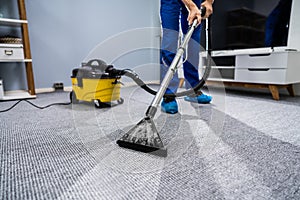 Person Cleaning Carpet With Vacuum Cleaner