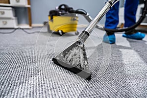 Person Cleaning Carpet With Vacuum Cleaner