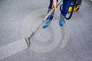 Person Cleaning Carpet With Vacuum Cleaner