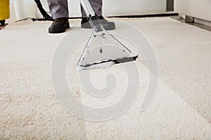 Person Cleaning Carpet With Vacuum Cleaner