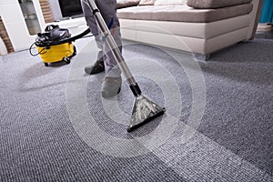 Person Cleaning Carpet With Vacuum Cleaner