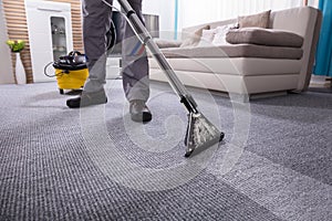 Person Cleaning Carpet With Vacuum Cleaner