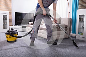 Person Cleaning Carpet With Vacuum Cleaner