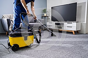 Person Cleaning Carpet With Vacuum Cleaner