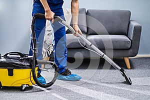 Person Cleaning Carpet With Vacuum Cleaner