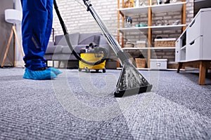 Person Cleaning Carpet With Vacuum Cleaner