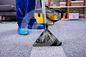 Person Cleaning Carpet With Vacuum Cleaner