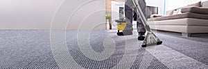 Person Cleaning Carpet With Vacuum Cleaner