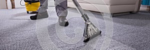 Person Cleaning Carpet With Vacuum Cleaner