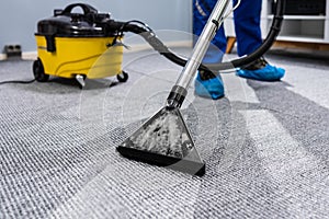 Person Cleaning Carpet With Vacuum Cleaner