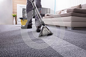 Person Cleaning Carpet With Vacuum Cleaner photo