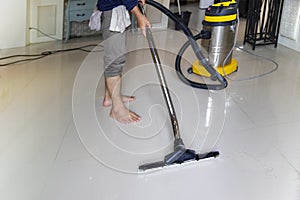 The person  cleaning floor with professional equipment in the living room