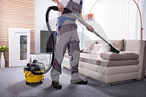 Person Cleaning Sofa With Vacuum Cleaner