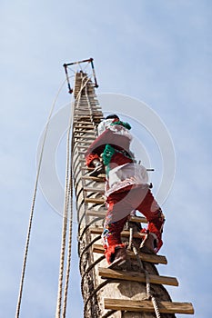 Person climbing a pole for Danza de los Voladores in Cuetzalan del Progreso, Puebla, Mexico photo