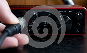 Person connecting a cable to an audio interface