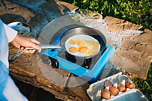 Person cooking eggs on camping stove