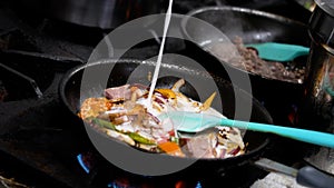 Person cooking and preparing traditional Thai cuisine in pans.