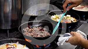 Person cooking and preparing traditional Thai cuisine in pans.