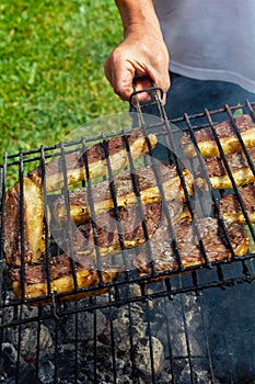 Person cooking steaks on a barbecue grill