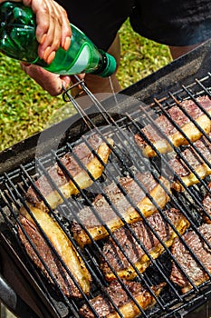 Person cooking steaks on a barbecue grill