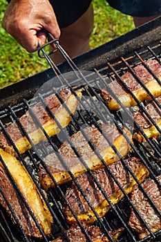 Person cooking steaks on a barbecue grill