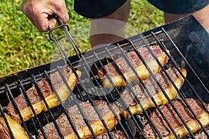 Person cooking steaks on a barbecue grill