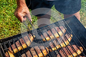 Person cooking steaks on a barbecue grill