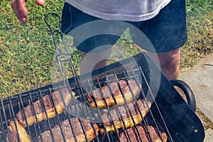 Person cooking steaks on a barbecue grill